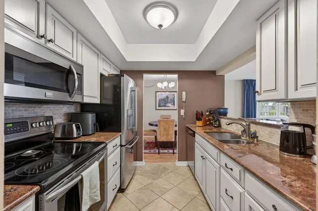 a large kitchen with stainless steel appliances granite countertop a stove and a sink