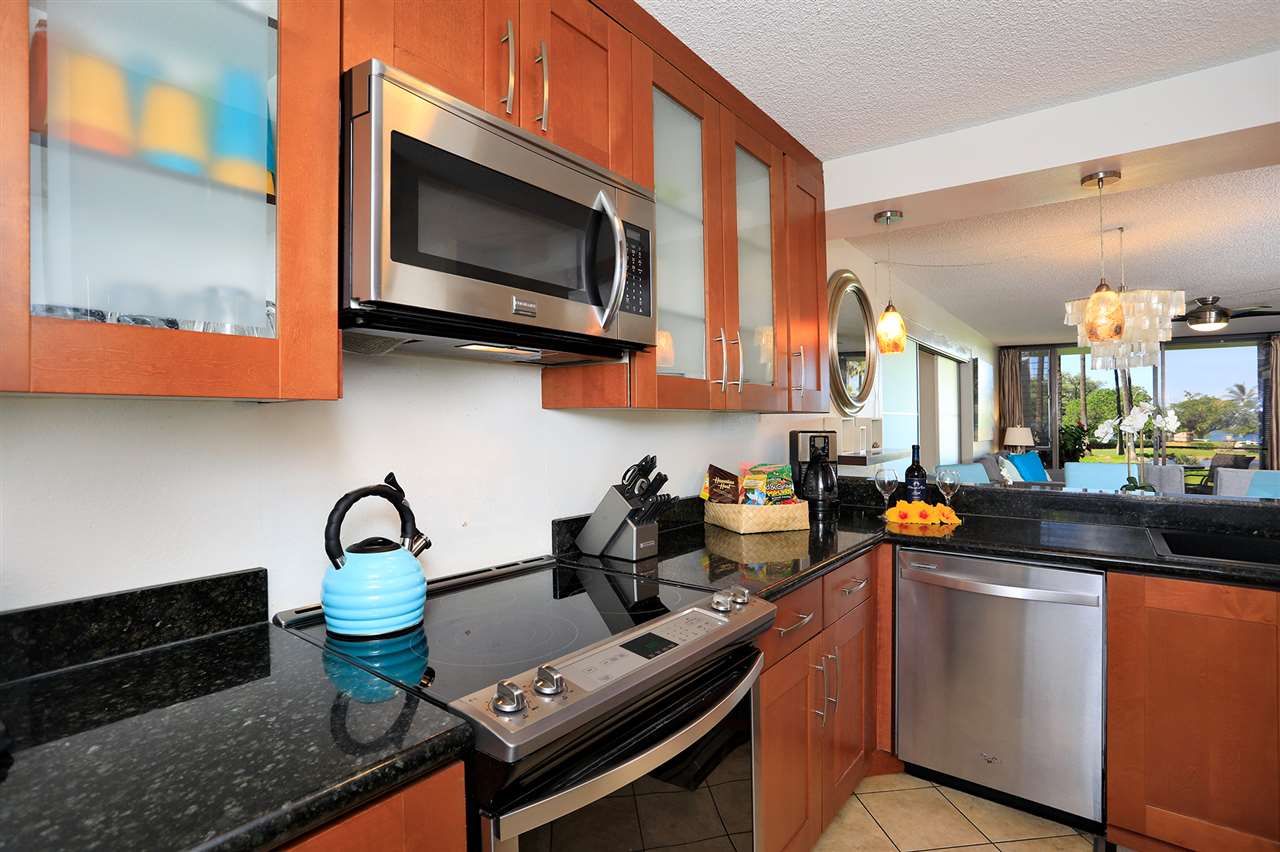 2695 South Kihei Road, Unit 10115 Kihei, HI 96753 - Photo 2 of 28 a kitchen with stainless steel appliances a stove a sink and a microwave