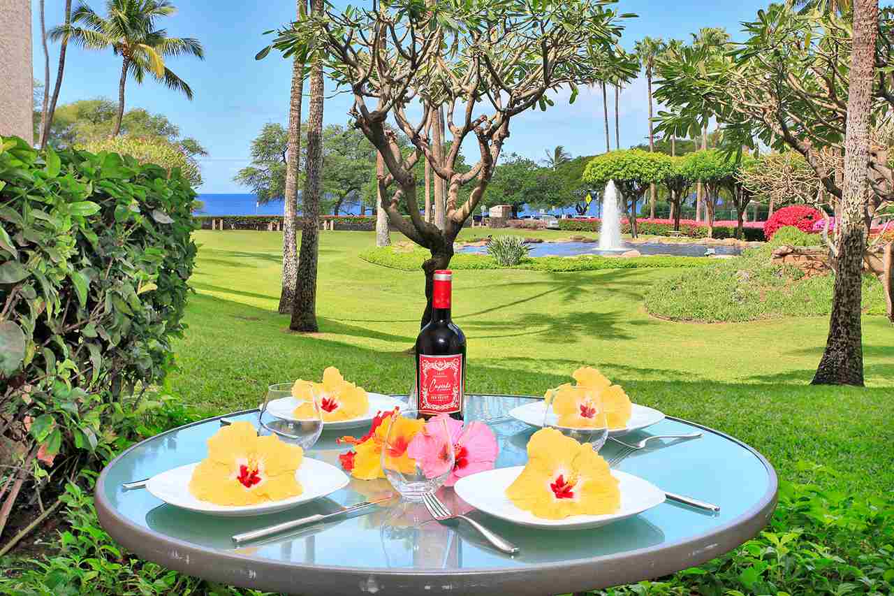 2695 South Kihei Road, Unit 10115 Kihei, HI 96753 - Photo 4 of 28 a backyard of a house with table and chairs plants and large tree