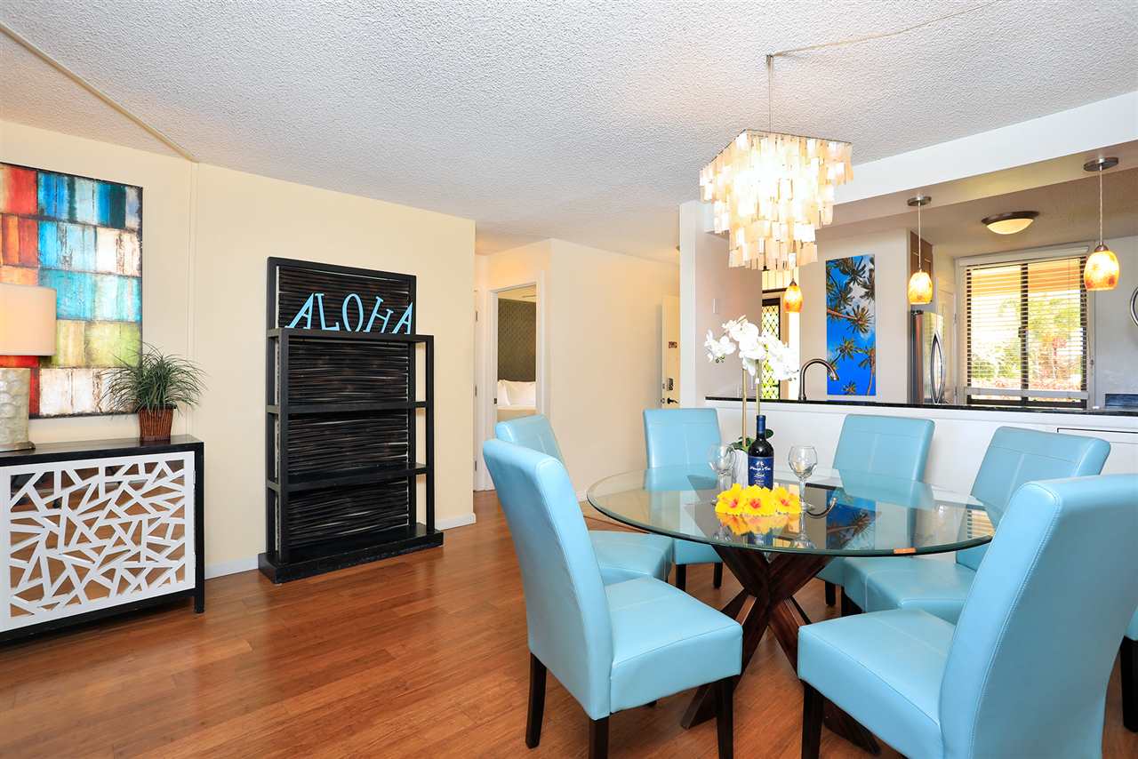 2695 South Kihei Road, Unit 10115 Kihei, HI 96753 - Photo 7 of 28 a view of a dining room with furniture wooden floor and chandelier