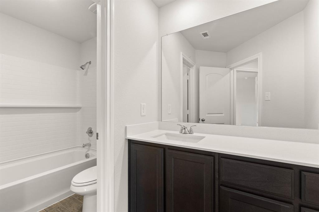2841 Hay Lane Midlothian, TX 76065 - Photo 18 of 27 a bathroom with a sink a toilet and a large mirror