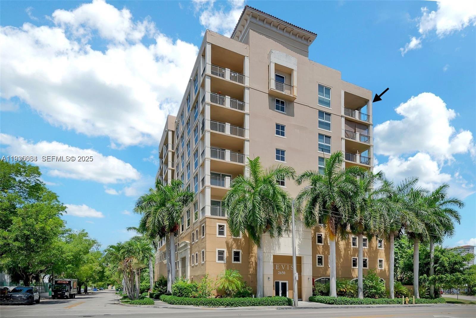 a front view of multi story residential apartment building with yard and parking space
