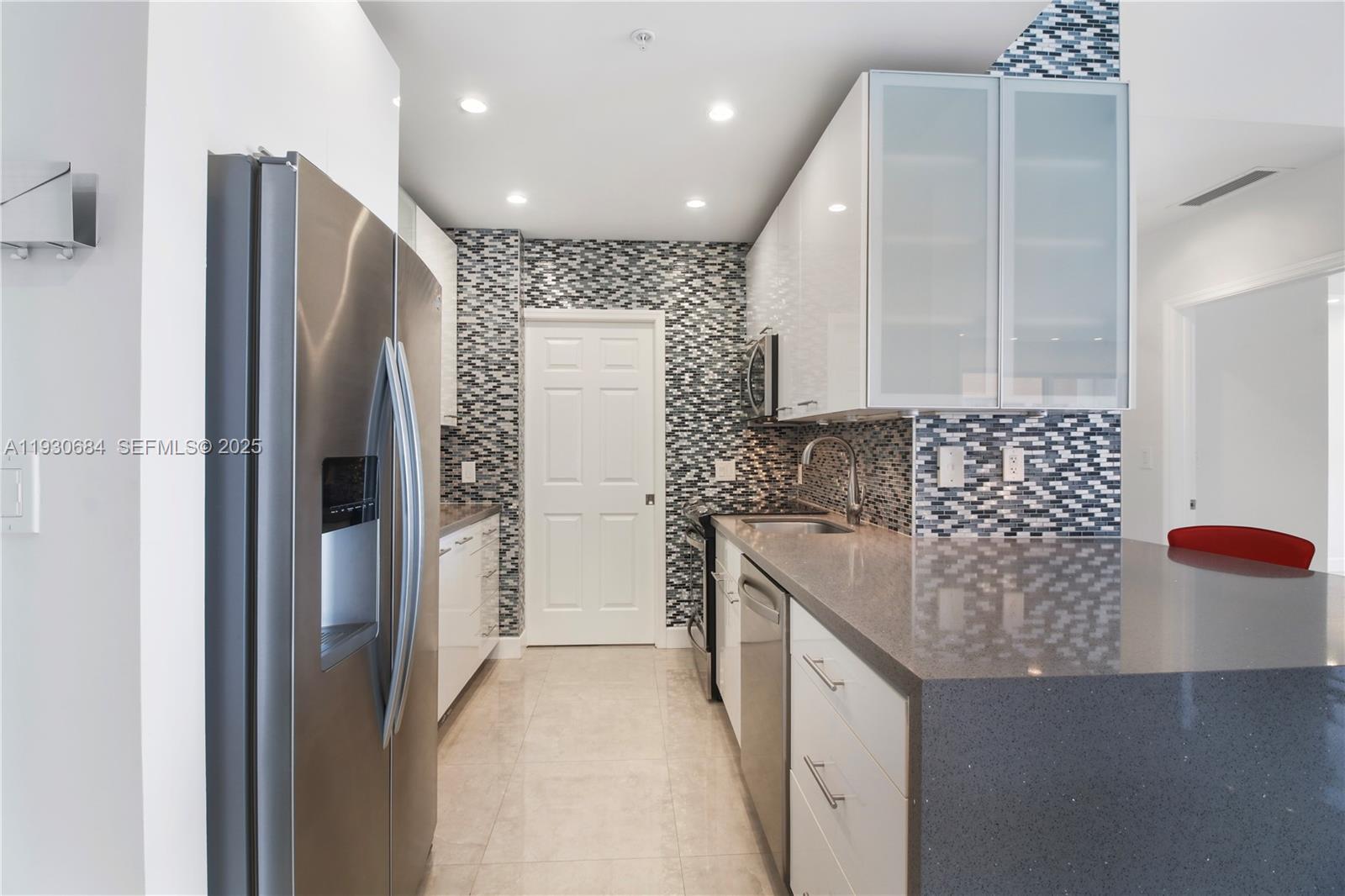 2650 Southwest 37th Avenue, Unit 901 Miami, FL 33134 - Photo 12 of 31 a kitchen with stainless steel appliances granite countertop a refrigerator and a sink