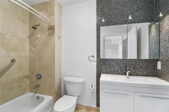 a bathroom with a sink a toilet a mirror and shower