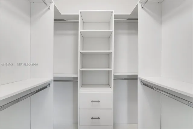 a view of walk in closet with empty racks