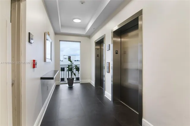 a hallway with wooden floor table and chairs