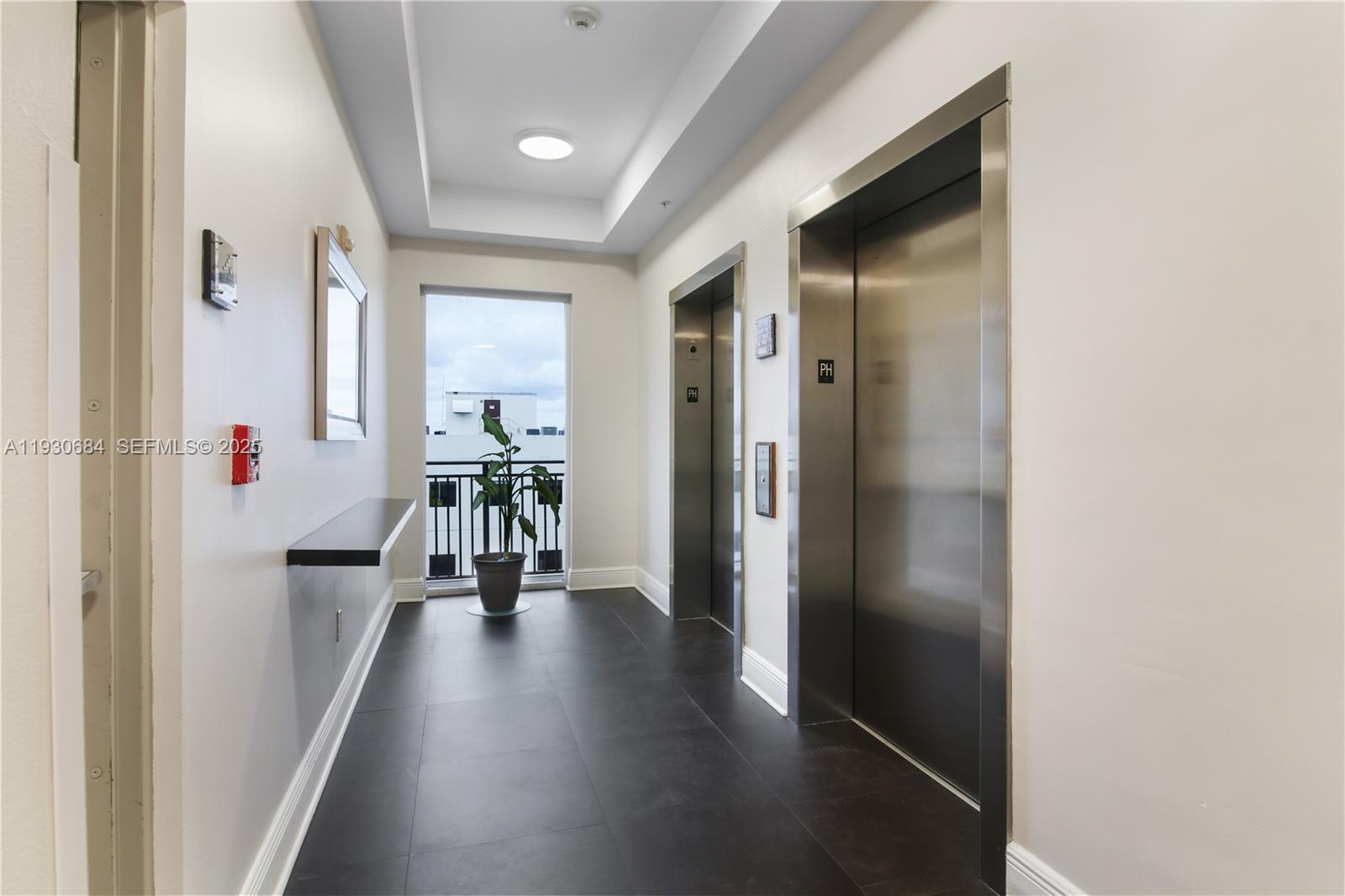 2650 Southwest 37th Avenue, Unit 901 Miami, FL 33134 - Photo 25 of 31 a hallway with wooden floor table and chairs