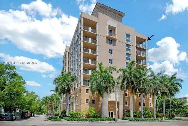 a front view of multi story residential apartment building with yard and parking space