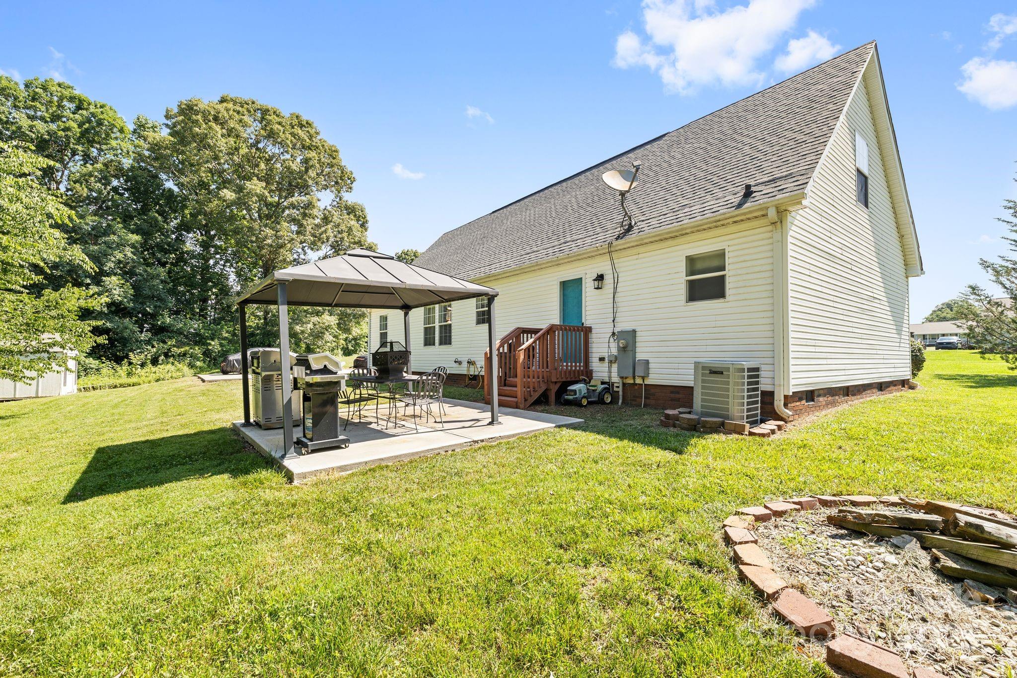 118 Grain Drive Stony Point, NC 28678 - Photo 21 of 31 a view of a patio with table and chairs under an umbrella