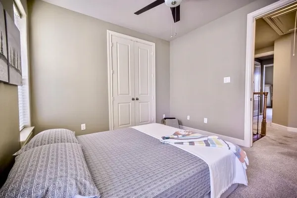 a bedroom with a bed and painting on the wall