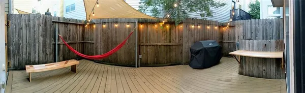 an outdoor sitting area with furniture and wooden fence