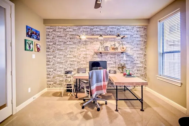 a view of a workspace with furniture and a window