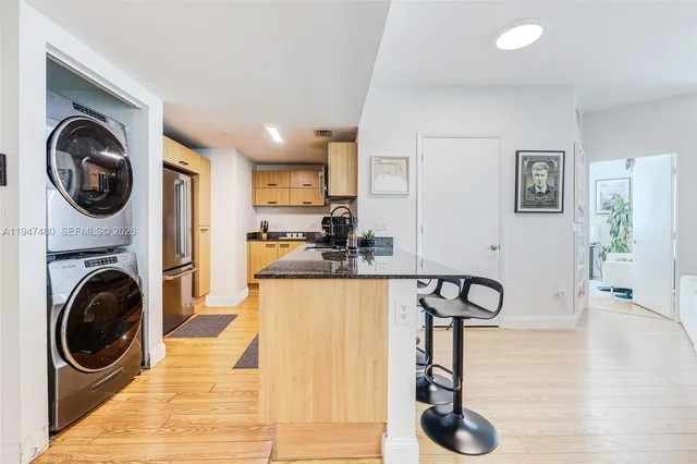 a view of a kitchen with a sink washer and dryer