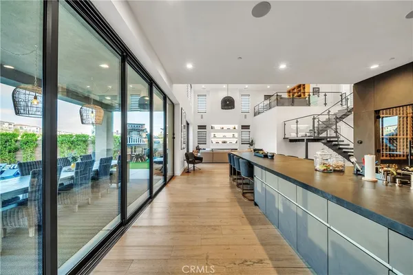 a living room with couches and kitchen view with wooden floor
