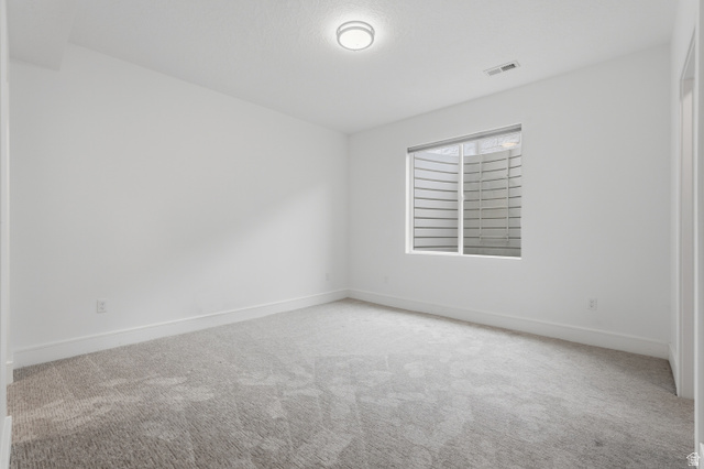 653 East Vandalay Lane Draper, UT 84020 - Photo 44 of 61 Neutral tone-on-tone room featuring soft patterned carpet, white baseboards, and a contemporary flush-mount ceiling light