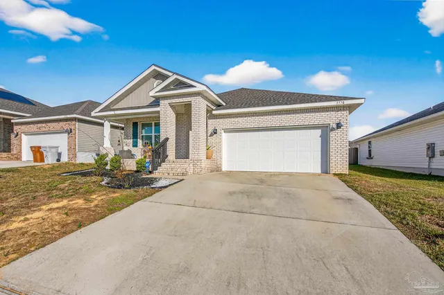 a front view of a house with yard and parking