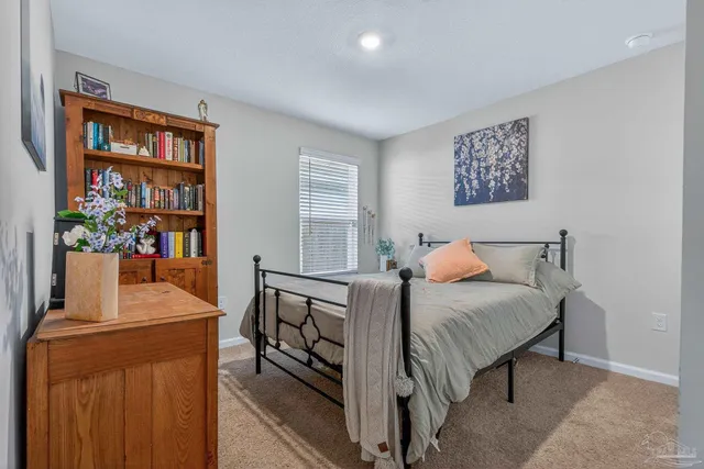 a view of a hallway with wooden floor and a bathroom