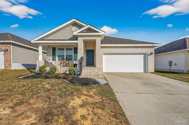 a front view of a house with a yard and potted plants