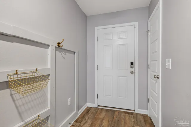 a hallway with wooden floor windows and a bathroom