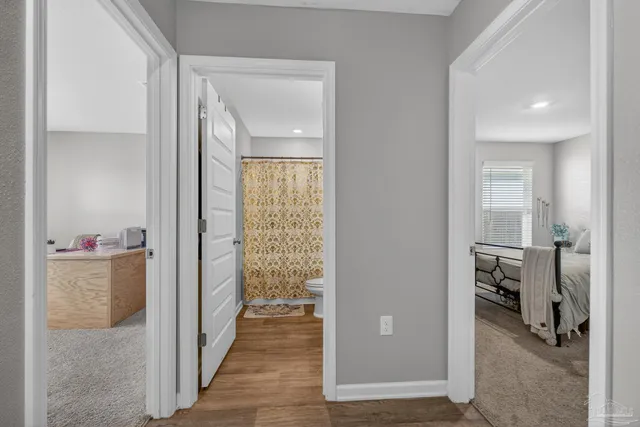 a bedroom with a bed and a computer on a desk next to a window