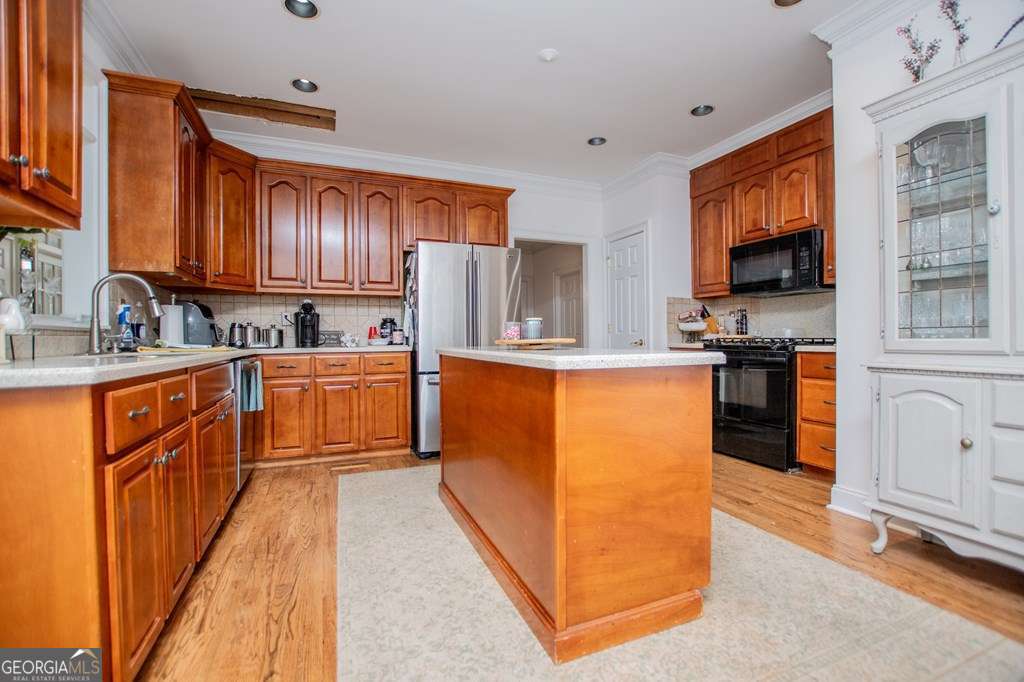 204 Pinehurst Way Carrollton, GA 30116 - Photo 14 of 61 a kitchen with stainless steel appliances granite countertop a stove top oven a sink dishwasher and a refrigerator with wooden floor