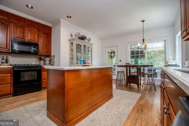 a kitchen with kitchen island granite countertop a sink stove and cabinets