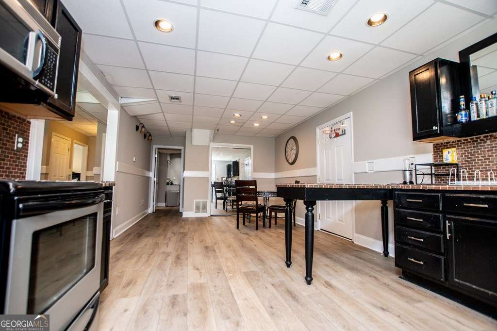 204 Pinehurst Way Carrollton, GA 30116 - Photo 34 of 61 a kitchen with stainless steel appliances granite countertop a stove a refrigerator a sink dishwasher a dining table and chairs with wooden floor
