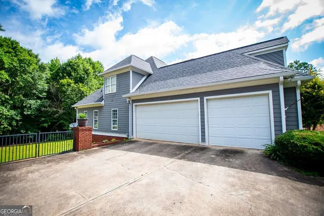 a front view of a house with a yard and green space