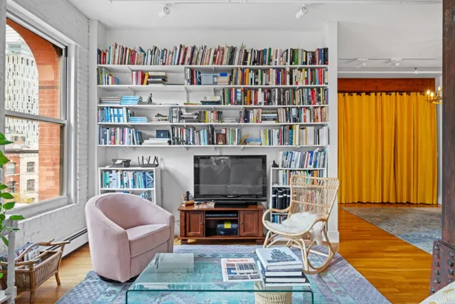 a living room with fireplace furniture and a book shelf