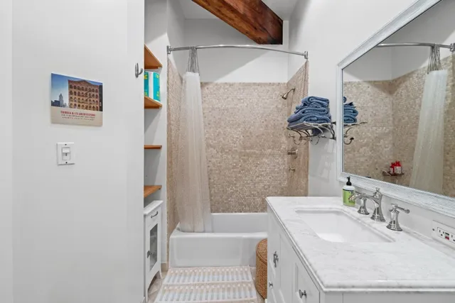 a bathroom with a granite countertop sink a mirror and a bathtub