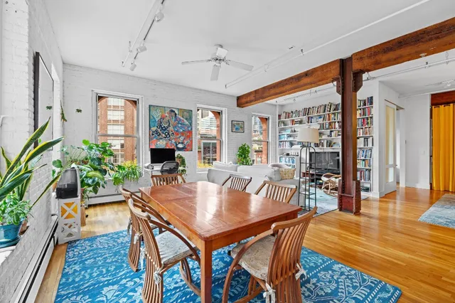 a dining room with furniture potted plants and wooden floor
