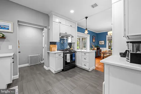 a kitchen with stainless steel appliances kitchen island hardwood floor and a sink