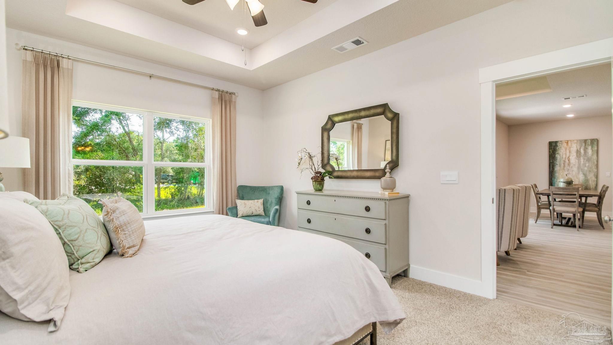 5860 Dove Nest Road Gulf Breeze, FL 32563 - Photo 15 of 31 a bedroom with a bed a mirror on dresser and a window