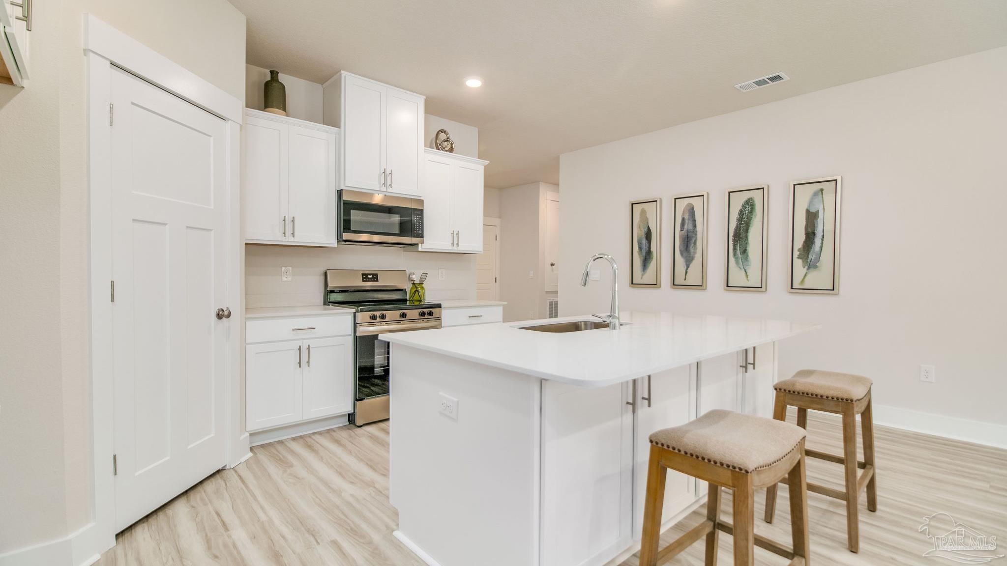 5860 Dove Nest Road Gulf Breeze, FL 32563 - Photo 2 of 31 a kitchen with a sink cabinets and wooden floor