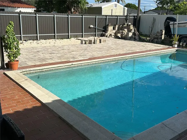 a swimming pool with a yard and wooden fence