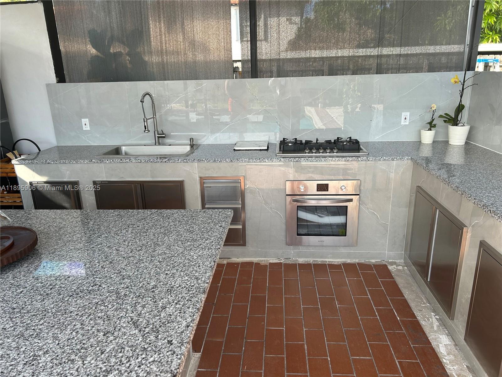 1821 Southwest 92nd Place Miami, FL 33165 - Photo 7 of 11 a kitchen with granite countertop a stove a sink and a microwave