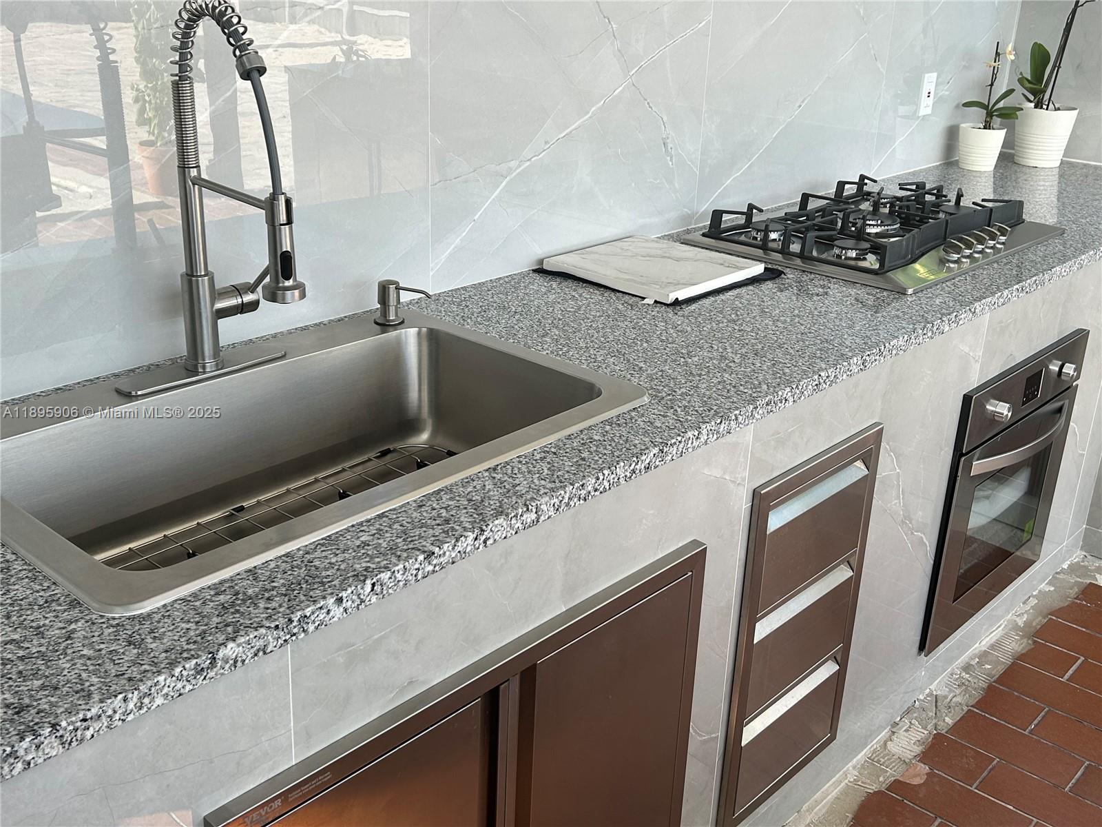 1821 Southwest 92nd Place Miami, FL 33165 - Photo 9 of 11 a kitchen with a sink and a stove top oven