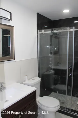 a bathroom with a sink a toilet and shower