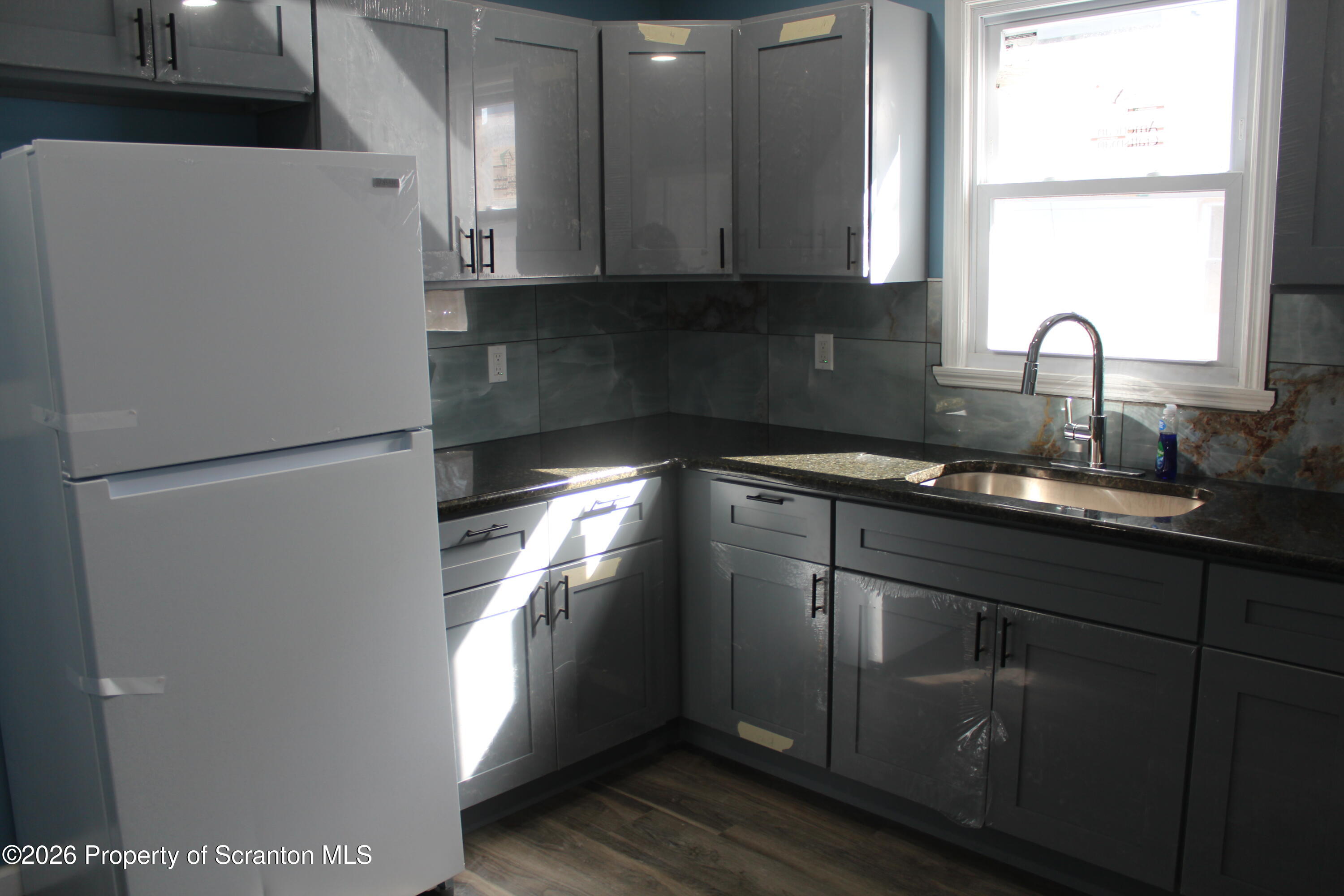 335 Phelps Street, Unit 1 Scranton, PA 18509 - Photo 6 of 12 a kitchen with a refrigerator and a sink