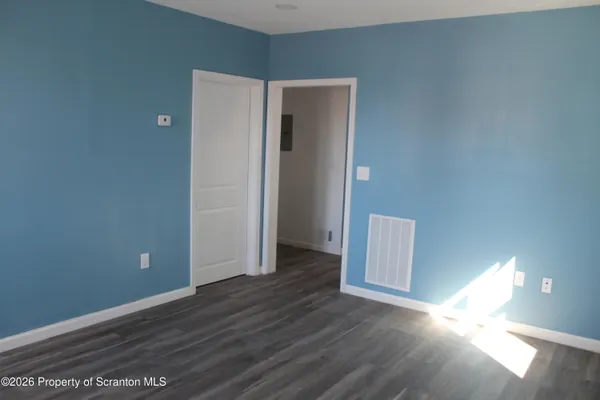 a view of an empty room with wooden floor