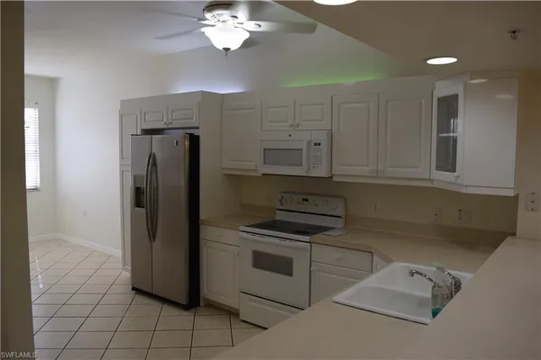 a kitchen with a refrigerator sink and cabinets