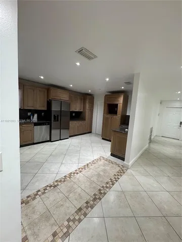 a kitchen with stainless steel appliances granite countertop a refrigerator and a stove top oven