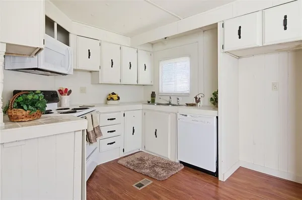a kitchen with cabinets appliances a sink and a counter top space
