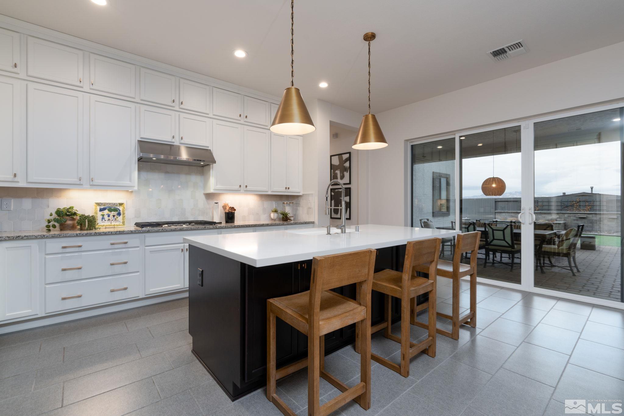 2343 Iron Square Drive Reno, NV 89521 - Photo 10 of 35 a kitchen with kitchen island granite countertop a table chairs sink and cabinets