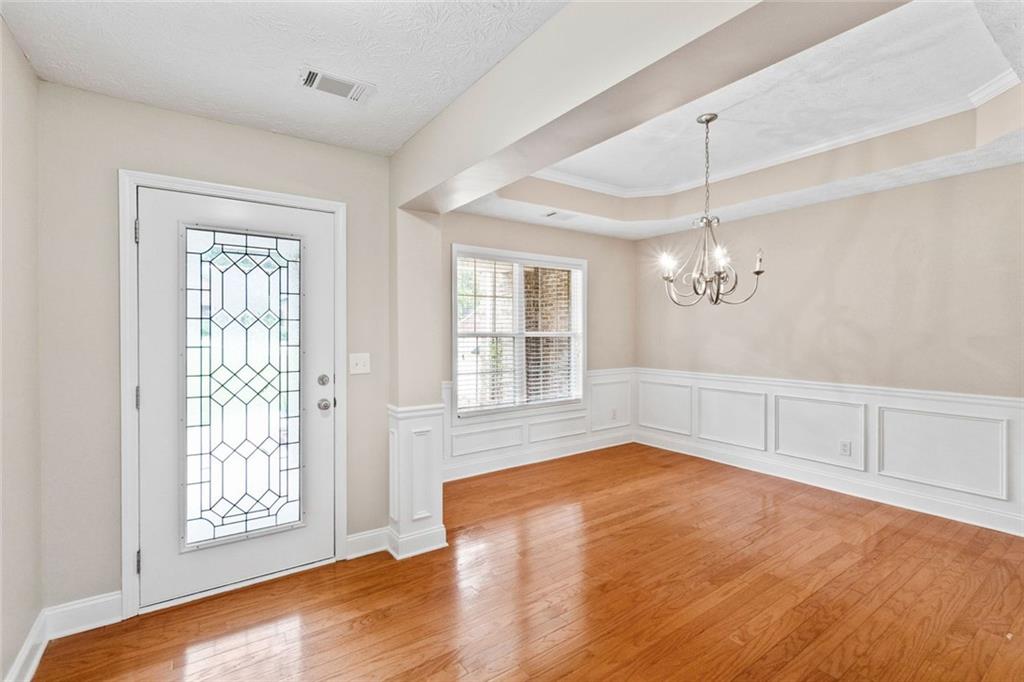 241 Red Bud Road Jefferson, GA 30549 - Photo 2 of 43 a view of an empty room with chandelier and wooden floor