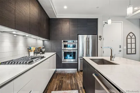 a kitchen that has a sink stainless steel appliances a counter space and cabinets