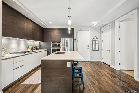 a kitchen with kitchen island a stove a refrigerator and a cabinets with wooden floor