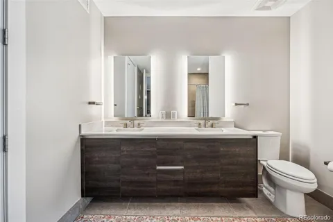 a bathroom with a granite countertop toilet a sink and a mirror