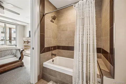 a bathroom with a tub shower and sink