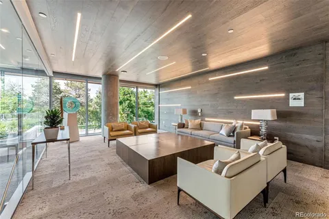 a living room with couches a coffee table and a large window with outer view